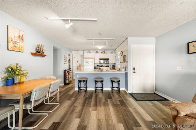 kitchen with dark hardwood / wood-style flooring, white fridge, and a textured ceiling