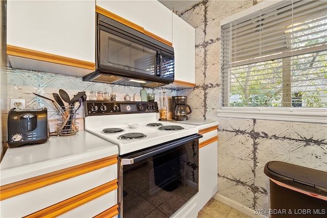 6005 Baydy Peak Rd Unit 102, Osage Beach, MO 65065 - kitchen with range with electric cooktop, black microwave, light countertops, white cabinetry, and backsplash