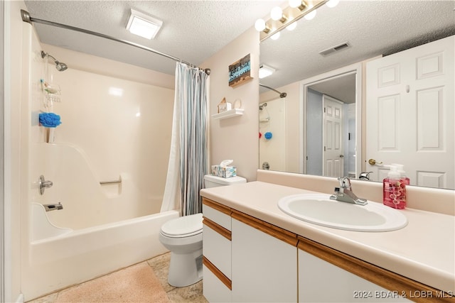 full bathroom featuring vanity, tile patterned flooring, toilet, a textured ceiling, and shower / tub combo