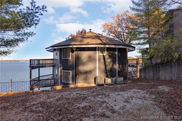 view of outdoor structure featuring central AC and a water view