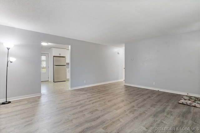 unfurnished room with light wood-style floors and baseboards