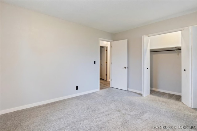 unfurnished bedroom with carpet floors, a closet, and baseboards