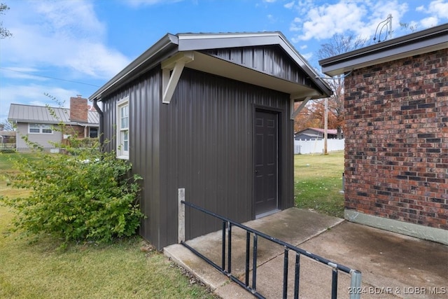 view of outdoor structure with fence and an outbuilding