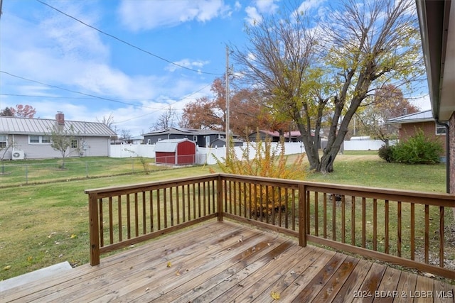 deck featuring a yard, a shed, an outdoor structure, and a fenced backyard