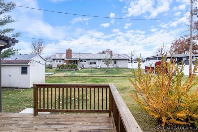 wooden deck featuring a storage shed, a yard, an outdoor structure, and fence