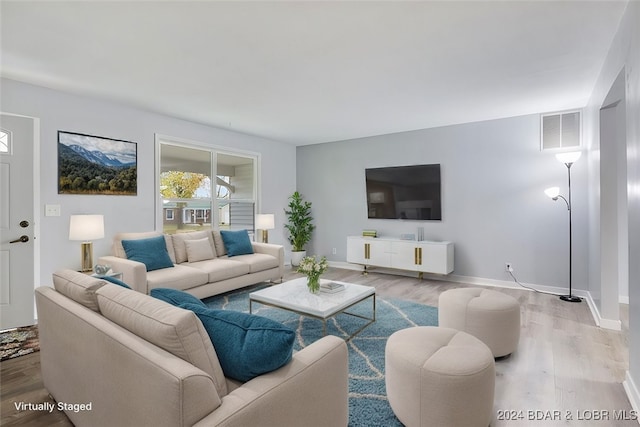 living area with visible vents, baseboards, and wood finished floors