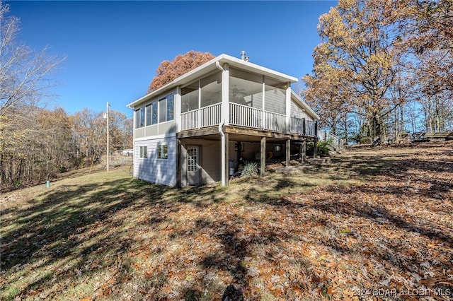 rear view of house with ceiling fan and a sunroom