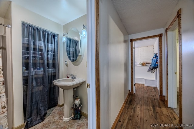 bathroom featuring a textured ceiling and hardwood / wood-style flooring