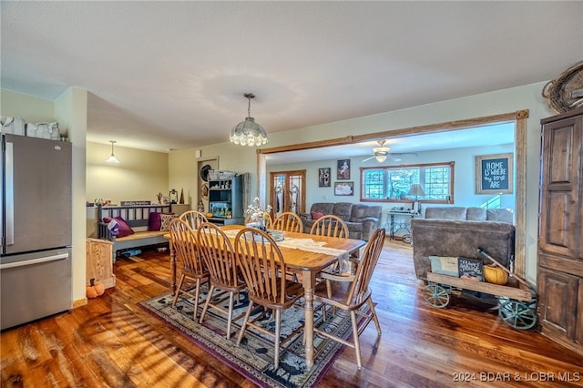 dining area with hardwood / wood-style floors and ceiling fan with notable chandelier