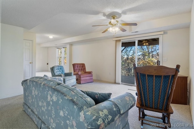 living room featuring light colored carpet, a healthy amount of sunlight, and a textured ceiling