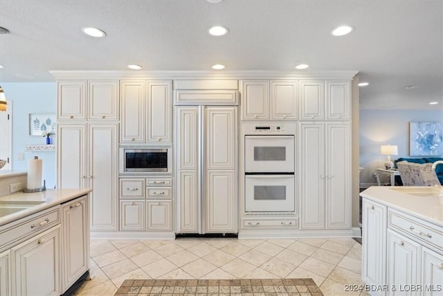 kitchen featuring built in appliances and light tile patterned floors