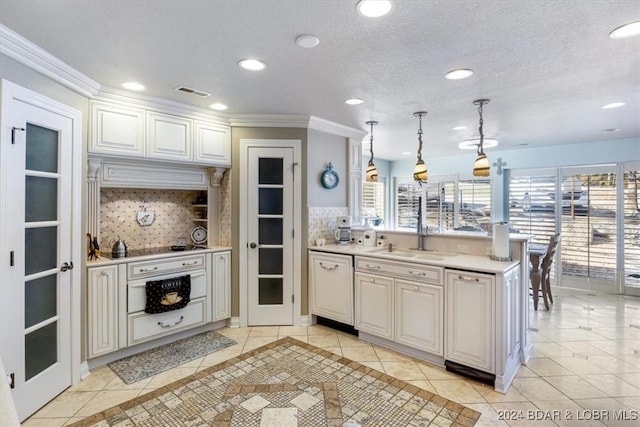 kitchen featuring tasteful backsplash, dishwashing machine, sink, and hanging light fixtures