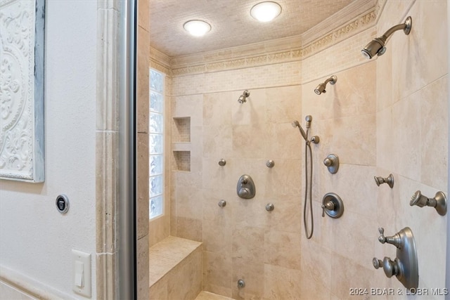 bathroom featuring tiled shower and crown molding