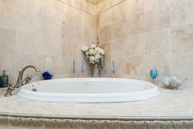 bathroom with a relaxing tiled tub and tile walls