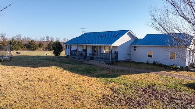 view of front facade featuring covered porch, a trampoline, and a front yard