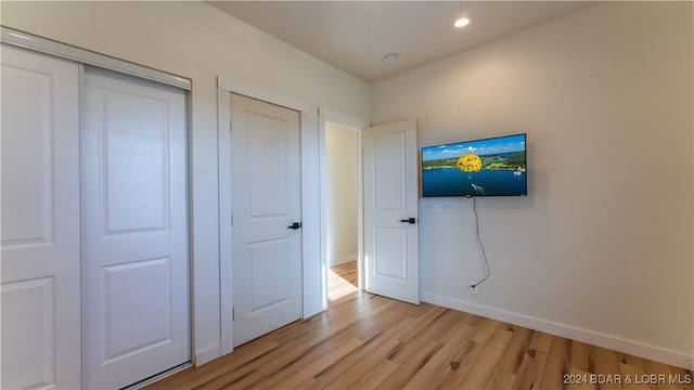 unfurnished bedroom featuring light hardwood / wood-style floors and a closet