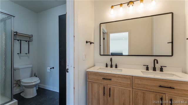 bathroom featuring tile patterned flooring, vanity, toilet, and a shower with shower door