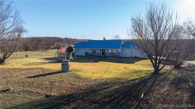 view of front facade featuring covered porch, a trampoline, and a front yard