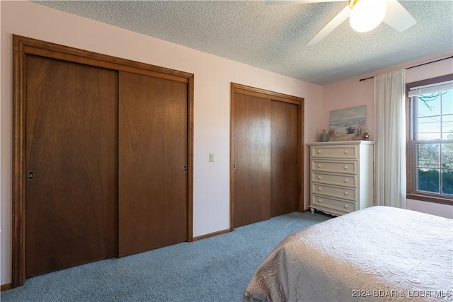 bedroom featuring a textured ceiling, light colored carpet, and ceiling fan