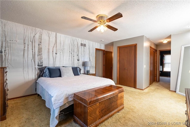 bedroom featuring light carpet, a textured ceiling, and ceiling fan