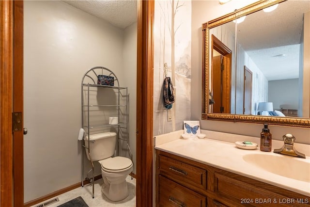 bathroom with vanity, a textured ceiling, and toilet