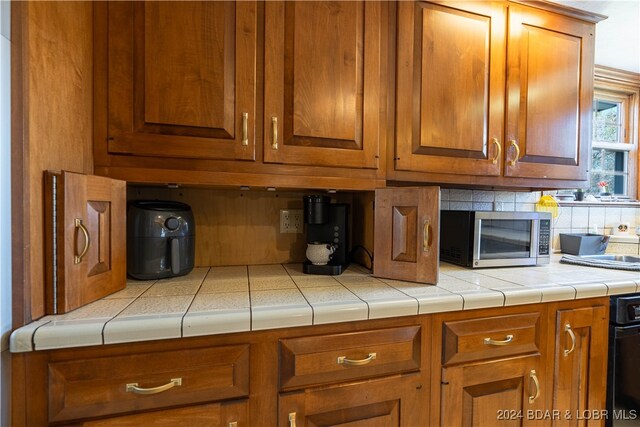 kitchen featuring decorative backsplash and tile counters