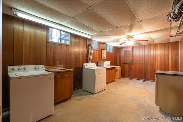 washroom featuring cabinets, ceiling fan, washer and clothes dryer, sink, and wood walls