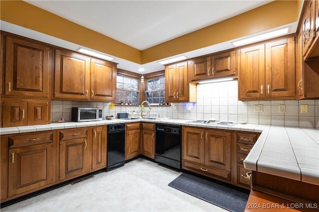 kitchen with dishwasher, sink, tile countertops, and white gas stovetop