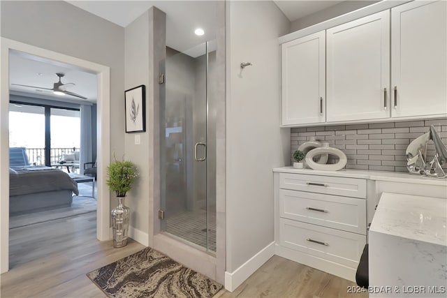 bathroom with tasteful backsplash, ceiling fan, hardwood / wood-style floors, and a shower with shower door