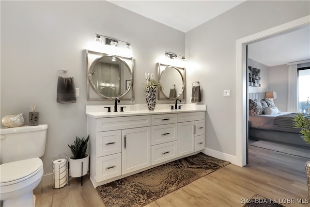 bathroom with toilet, vanity, and hardwood / wood-style flooring