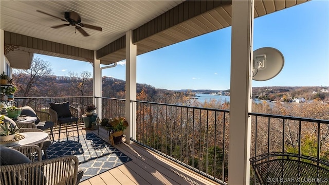 deck with a water view and ceiling fan