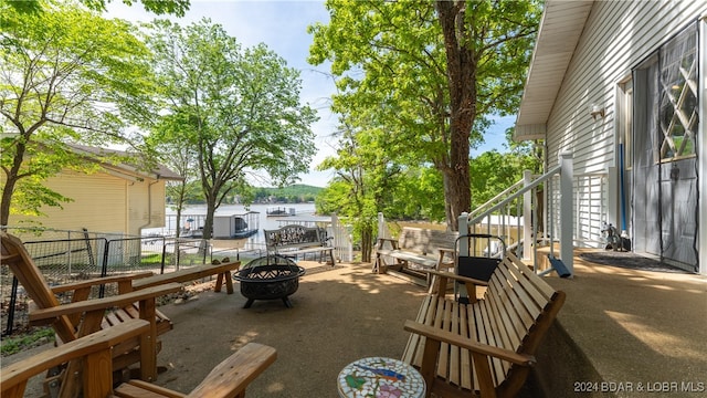 view of patio with a water view and an outdoor fire pit