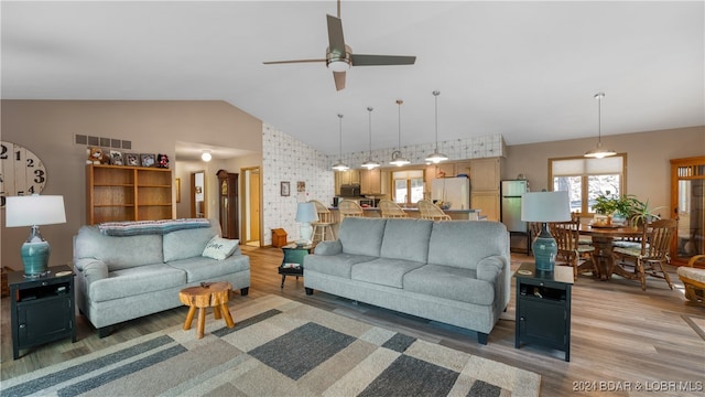 living room featuring hardwood / wood-style flooring, ceiling fan, and lofted ceiling