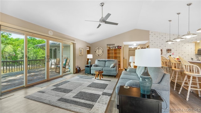 living room featuring lofted ceiling, ceiling fan, and wood-type flooring