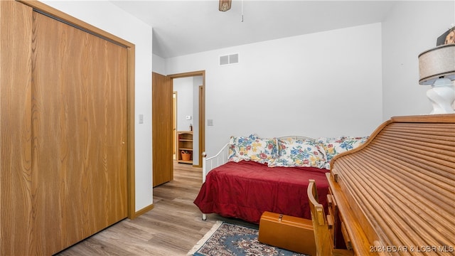 bedroom with light wood-type flooring and a closet