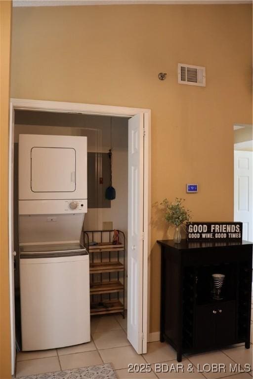 611 Lazy Days Rd Unit C9, Osage Beach, MO 65065 - laundry area with stacked washer / drying machine, light tile patterned floors, electric panel, and baseboards