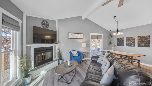 living room featuring hardwood / wood-style flooring, vaulted ceiling with beams, and ceiling fan with notable chandelier