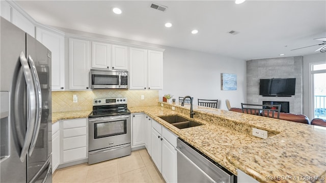 kitchen with white cabinets, kitchen peninsula, sink, and appliances with stainless steel finishes