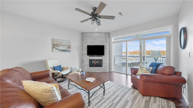 living room featuring a fireplace, hardwood / wood-style flooring, and ceiling fan