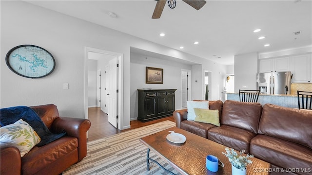 living room with ceiling fan and light hardwood / wood-style floors