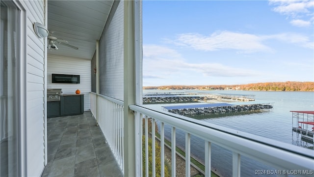 balcony with ceiling fan and a water view