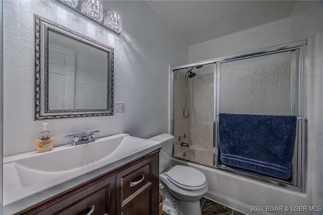 full bathroom featuring combined bath / shower with glass door, vanity, and toilet