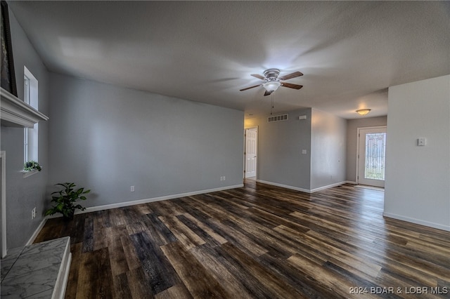 unfurnished living room featuring a textured ceiling, ceiling fan, and dark hardwood / wood-style floors