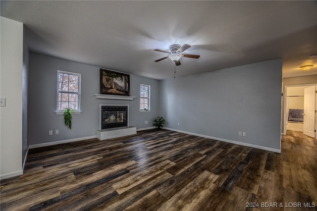 unfurnished living room with a textured ceiling, ceiling fan, and dark hardwood / wood-style floors