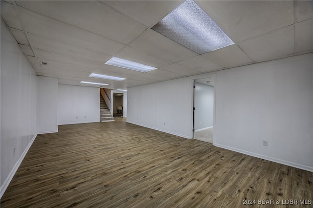 basement featuring a paneled ceiling and wood-type flooring