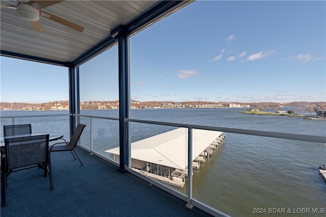 balcony featuring a water view and ceiling fan