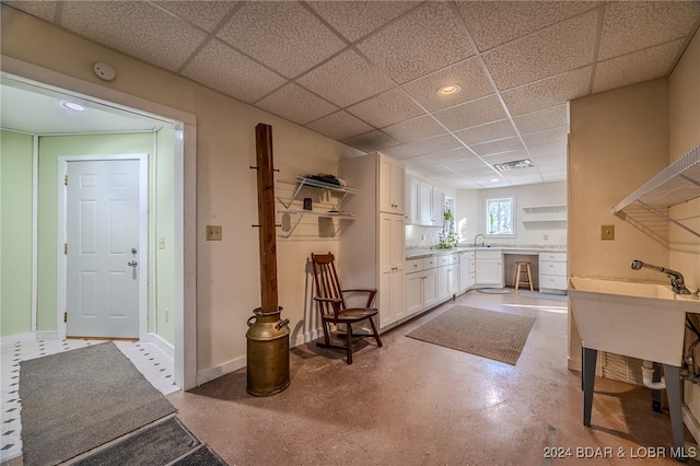 interior space featuring a drop ceiling and sink