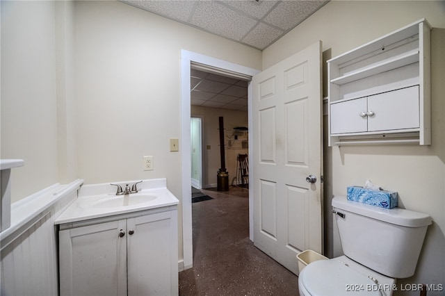 bathroom with vanity, a paneled ceiling, and toilet