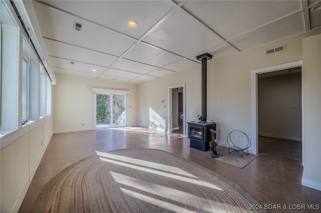 living room with a wood stove and concrete floors