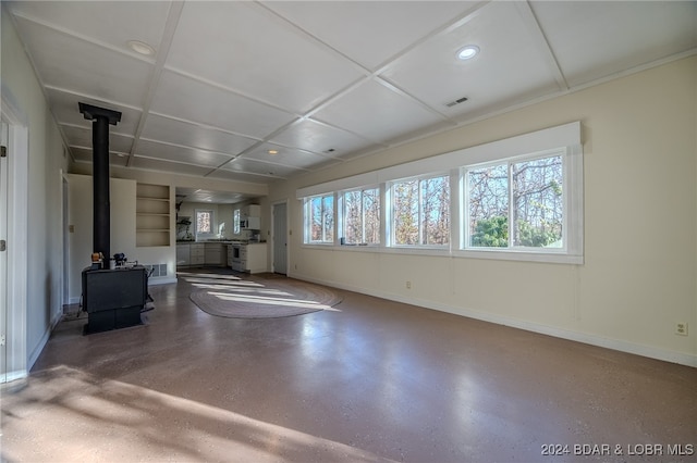 unfurnished living room with a wood stove and plenty of natural light